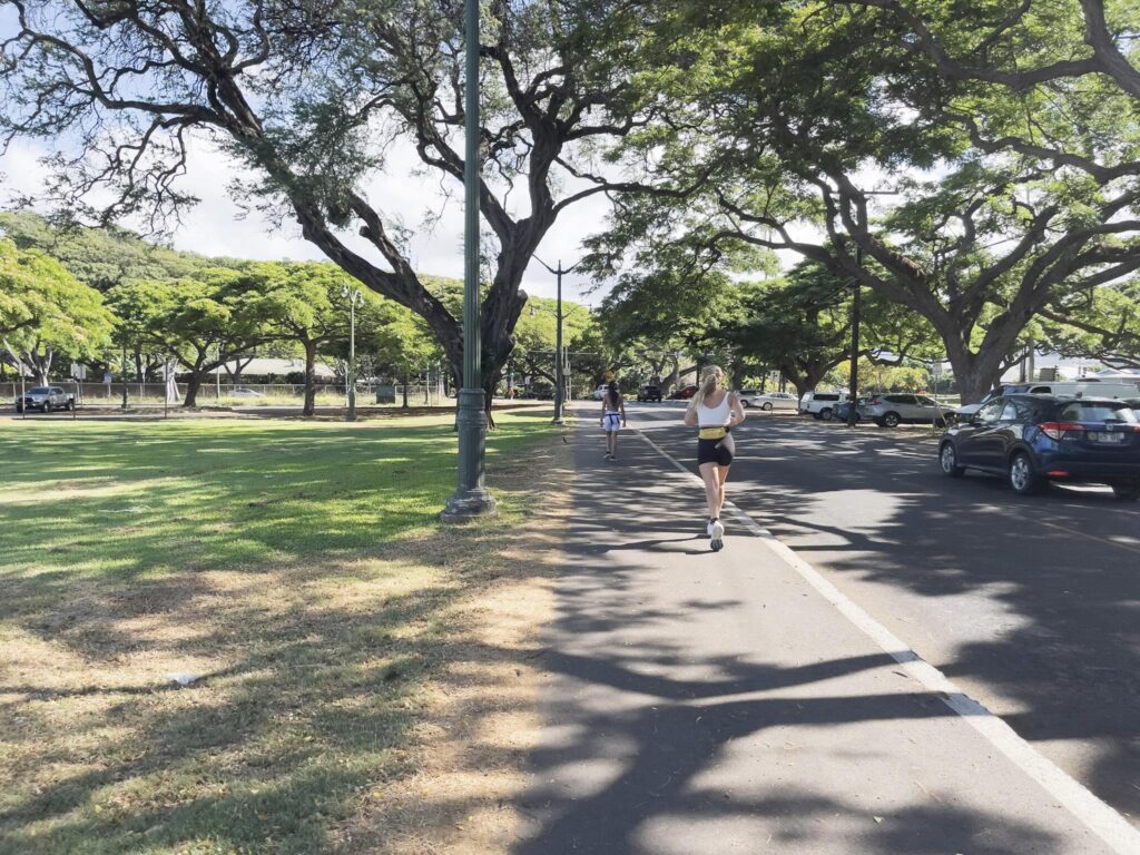 早朝のカピオラニ公園外周。朝のランニングを楽しむランナーたちが走っている。